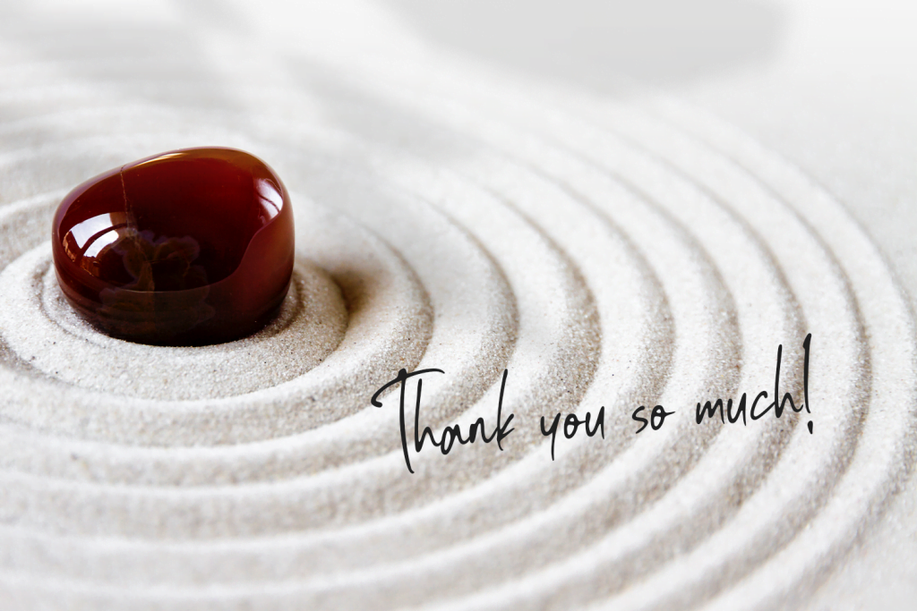 a stone on sand with a thank you message